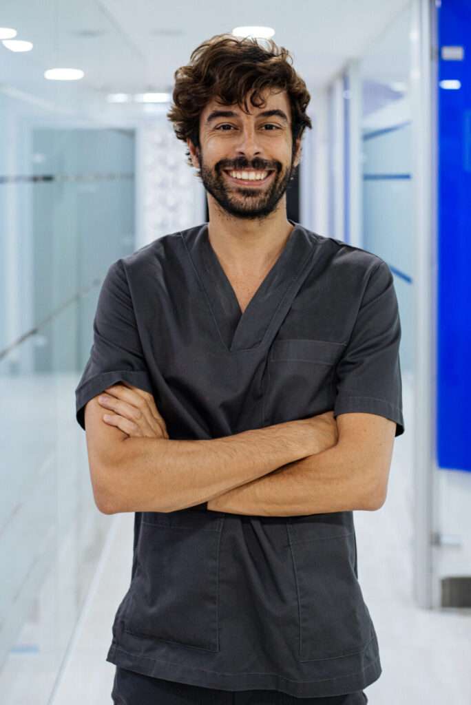 elegant confident man doctor dentist wearing lab coat looking at camera