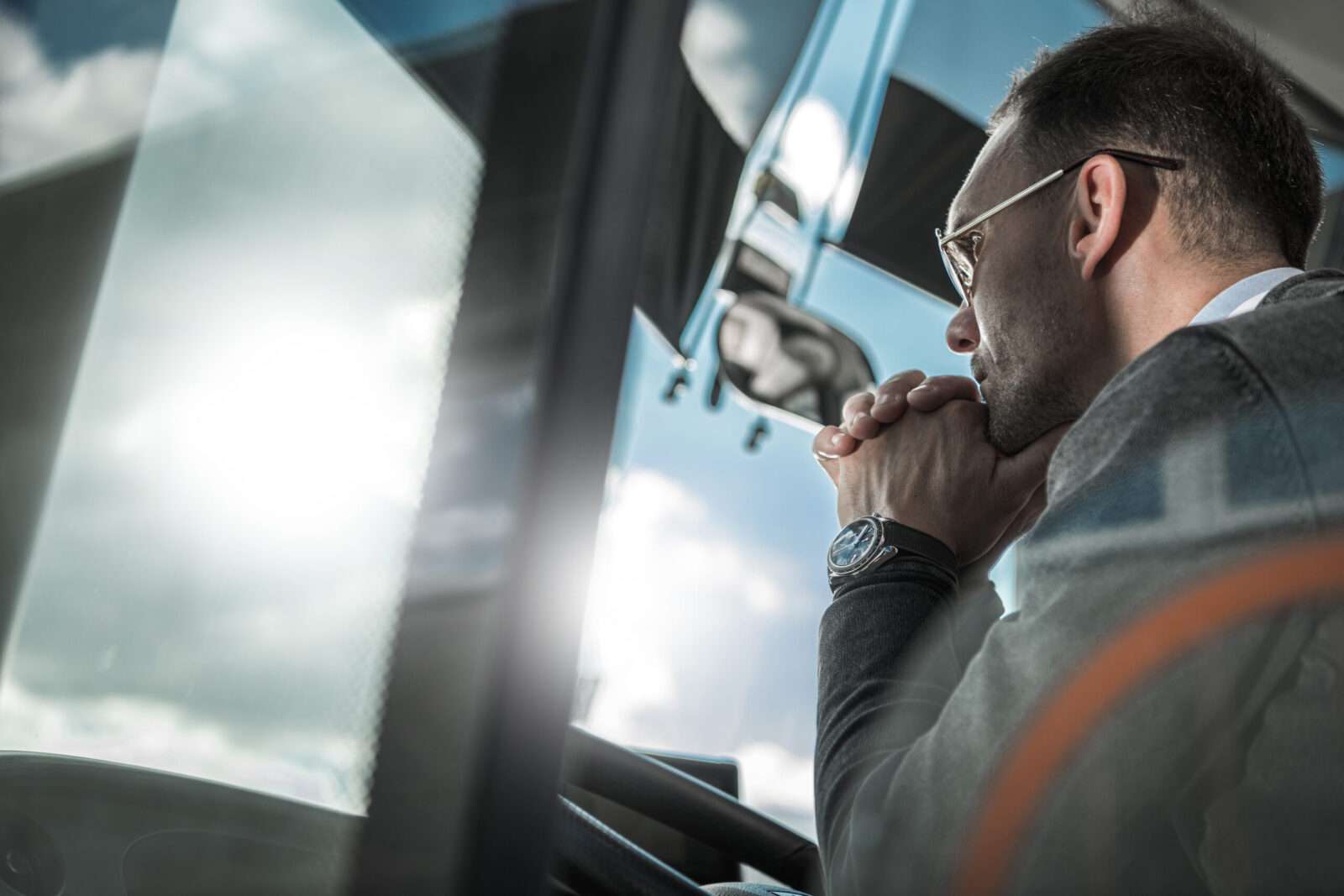 Confused and Pensive Bus Coach Driver Behind Vehicle Wheel Thinking About the Future of His Transportation Business.