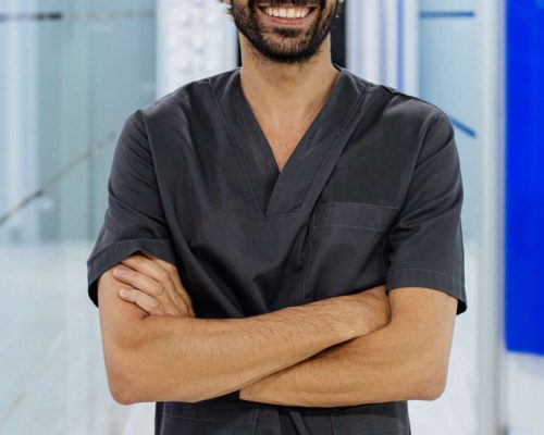 elegant confident man doctor dentist wearing lab coat looking at camera